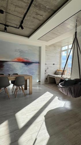a room with a table and a hammock in it at Spacious modern loft on Perfetskogo in Lviv
