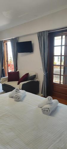 a hotel room with two beds with towels on them at A&Bpikermistudios in Pikérmion