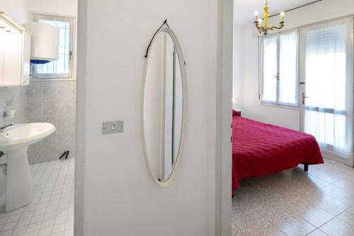 a bathroom with a mirror and a red bed at Erikbeach Bilo in Bibione