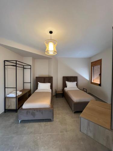 a bedroom with two beds and a chandelier at ORDAMS Villa in Himare