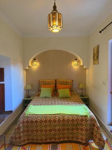 a bedroom with a large bed with orange pillows at Riad Medina Taroudant in Taroudant