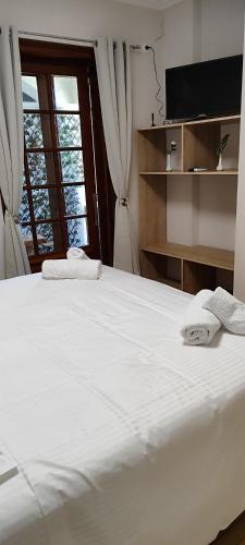 a bedroom with a white bed and a window at a&bpikermistudios4 in Pikérmion