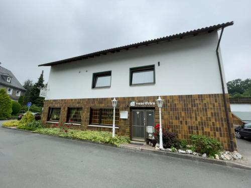 a brick building with a dog sitting in front of it at Hotel Haus Erlen in Olsberg
