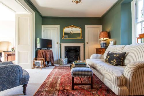 a living room with a couch and a fireplace at Grand Georgian Residence in Bath