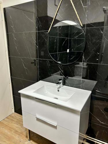 a bathroom with a white sink and a mirror at Appartement carmes in Aurillac