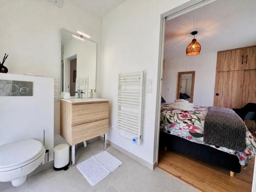 a bathroom with a bed and a sink and a toilet at L'Orée des Pins - Suite parentale - Merlimont in Merlimont