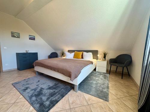 a bedroom with a bed and a chair at Altes Wasserwerk App 22 in Wustrow