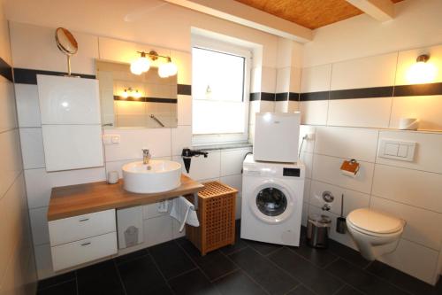 a bathroom with a sink and a washing machine at Ferienhaus LUV in Wustrow