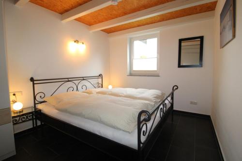 a bedroom with a black and white bed and a window at Ferienhaus LUV in Wustrow