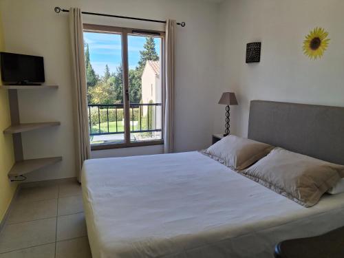 a bedroom with a bed and a large window at Le Cabanon de Laura in L'Isle-sur-la-Sorgue