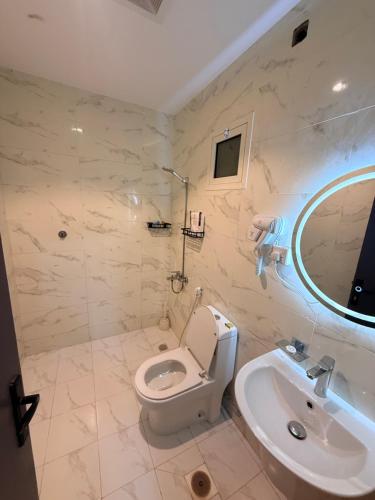 a bathroom with a white toilet and a sink at منازل الجود , أبحر - Manazil Al Joud , Obhour in Jeddah