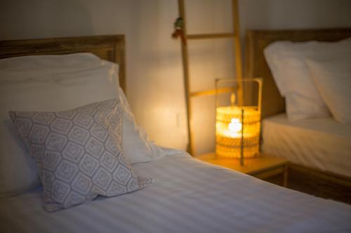 a bed with a pillow and a night stand with a lamp at Vera Nidhra - Self check-in after 6pm in Bangkok