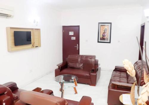 a living room with a couch and a chair at Aotel Hotel Lagos Owodunni in Ikeja