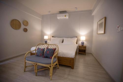 a bedroom with a bed and a chair and two lamps at Vera Nidhra - Self check-in after 6pm in Bangkok