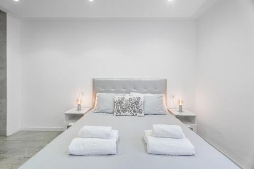 a white bedroom with a large white bed with two night stands at Olivia’s Beach in Candelaria