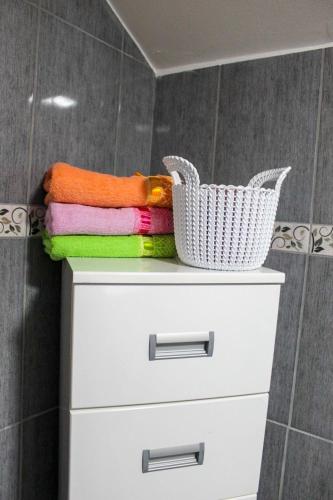 a stack of towels and a basket on a dresser in a bathroom at Vikendica Drinska Flora, Loznica - Lipnički Šor in Lipnički Šor