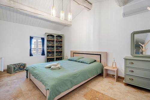 a bedroom with a large bed and a dresser at Maison l’Oustaou Cornillonnais in Cornillon-Confoux