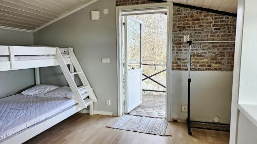 a bedroom with a bunk bed and a brick wall at Cozy seaside cottage SE09169 in Myggenäs