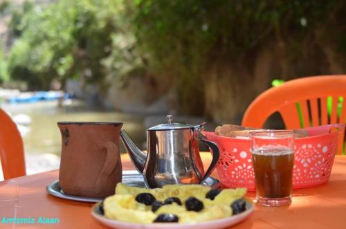 a plate of food with a tea pot and blueberries on a table at Sidi hssain in Amizmiz