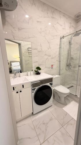 a bathroom with a sink and a washing machine at Raduga Resort Orion in Chon-Sary-Oy