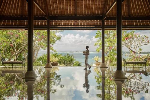 un hombre parado en medio de una piscina en una villa en Four Seasons Resort Bali at Jimbaran Bay, en Jimbaran