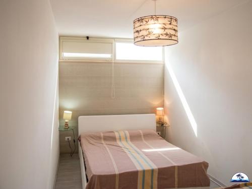 a small room with a bed and a chandelier at La Mozza 739 in Torre San Giovanni Ugento