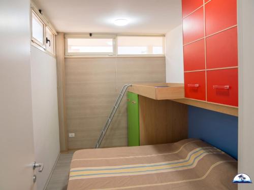 a small room with a bunk bed and red cabinets at La Mozza 739 in Torre San Giovanni Ugento