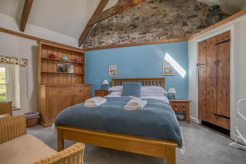 a bedroom with a large bed with blue walls at Ty Canol in Goodwick