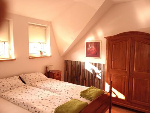 a bedroom with a bed and a wooden cabinet at Apartment Rozika in Slovenj Gradec