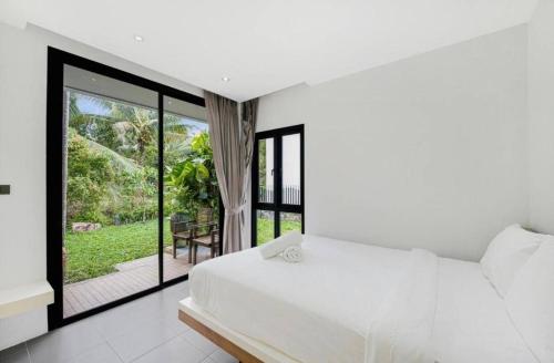 a bedroom with a white bed and a balcony at Anas house in Lipa Noi in Lipa Noi