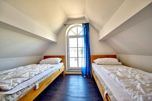 two beds in a room with a window at Haus Strandbrise Graal-Müritz in Graal-Müritz
