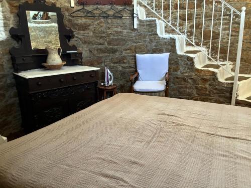 a bedroom with a table and a chair and stairs at The Windmill in Symi