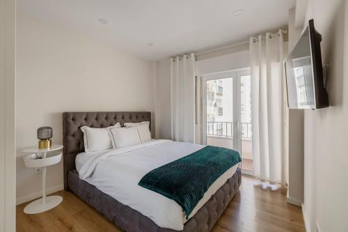 a bedroom with a large bed and a window at Modern apartment cloud 5 - Amadora in Falagueira