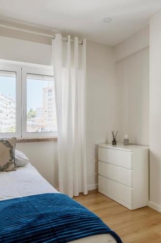 a white bedroom with a bed and a window at Modern apartment cloud 5 - Amadora in Falagueira