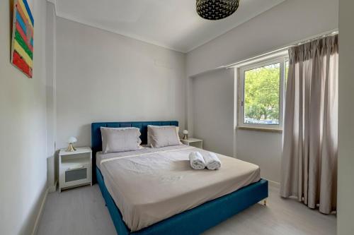 a bedroom with a blue bed and a window at Seixal River Retreat in Amora