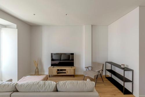 a living room with a couch and a tv at Vienna 1BR Calm & Cozy Escape in Caparica