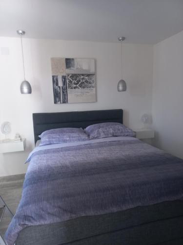 a bedroom with a large bed with purple sheets at Apartmani Lea in Bribir