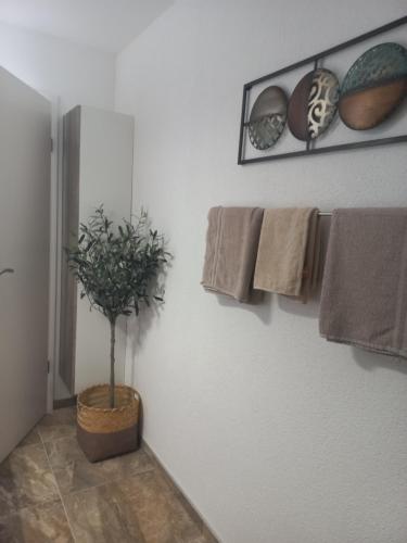 a bathroom with towels and a potted plant on the wall at Apartmani Lea in Bribir