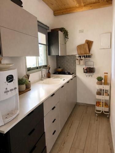 a kitchen with white cabinets and a sink at Cherry trees & mount Hermon views,near ram pool in Majdal Shams