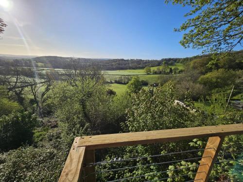 a view of a garden from a wooden deck at Cosy Treehouse in Pontypool