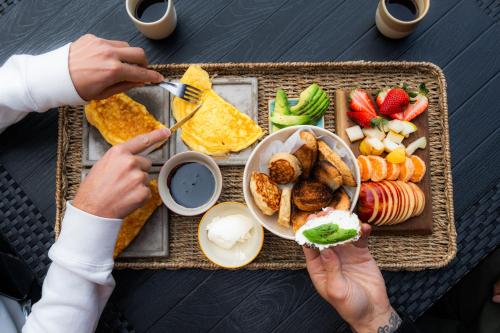 a table topped with a tray of food with people eating at El Remanso del Lago in Villa La Angostura