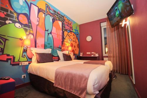 a hotel room with two beds with a painting on the wall at The Originals Boutique, Hôtel de l'Univers, Montluçon in Montluçon