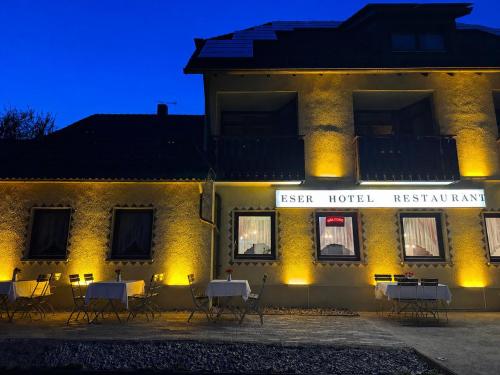a hotel with tables and chairs in front of a building at ESER Hotel Apartment in Hertingen