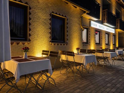 a group of tables and chairs in front of a building at ESER Hotel Apartment in Hertingen