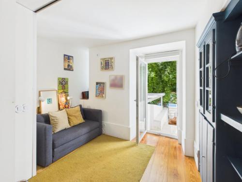 a living room with a couch and a window at Cozy 1BR, Private Terrace & Pool – Estrela | By Airnest in Lisbon