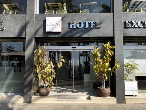 a hotel entrance with potted plants in front of it at Hotel Excelsior in Lloret de Mar