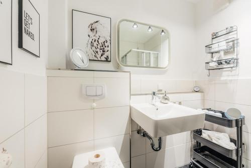 a white bathroom with a sink and a mirror at Halali Braunlage in Braunlage