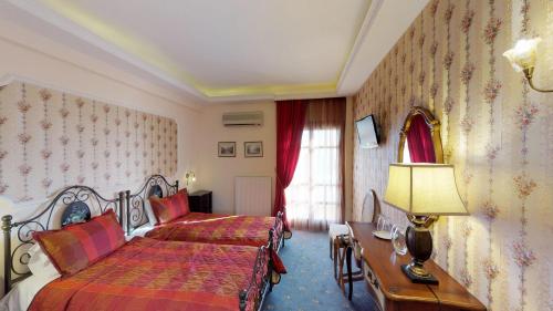 a bedroom with a bed and a table with a lamp at Hotel Mirto in Litochoro