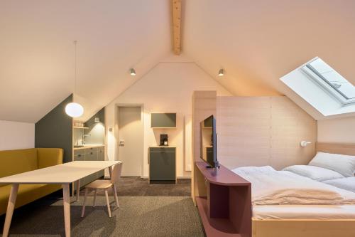 a bedroom with a bed and a desk and a table at Wohnen an der Mühlenwiese in Bad Sobernheim