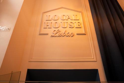 a sign on the front door of a local house institution at Local House Lisbon in Lisbon